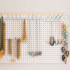 a white pegboard with lots of necklaces hanging on it