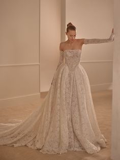 a woman in a wedding dress leaning against a wall with her arms out to the side