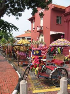 a bike with flowers on the back parked in front of a building