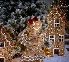 lighted gingerbread houses in front of a christmas tree