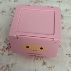 a pink lunch box with a face on it