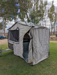 an outhouse tent is set up in the grass