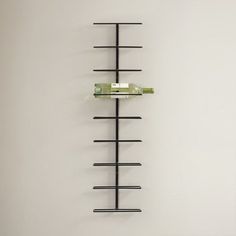 a white wall with a black rack and two wine bottles on it's sides