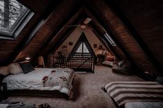 an attic bedroom with two beds and a baby crib