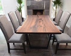 a dining room table with six chairs around it and a fireplace in the back ground