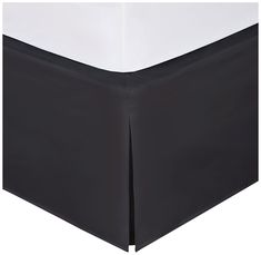 the black and white bed skirt is made up with two contrasting color sheets on it