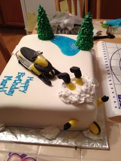 a cake that is sitting on top of a table with some frosting and decorations