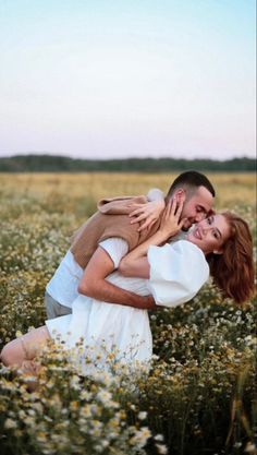 a man and woman hugging in a field of flowers