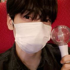 a boy wearing a face mask and holding a magnifying glass in front of his face