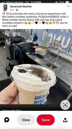 someone is holding up a cup of ice cream in front of a counter with other items on it