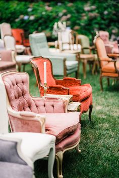 many different colored chairs sitting in the grass