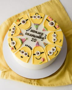 a birthday cake decorated with yellow and white frosting features minion faces as decorations