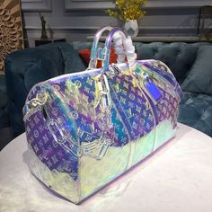 Description L.V Keepall Bandouliere 50 Monogram PVC Iridescent Prism By Virgil Abloh For Men, Bags, Travel Bags 19.7in/50cm LV M53271 Rep 1:1 One of the most highly sought after pieces from Virgil Abloh’s men’s Spring Summer 2019 collection, this holographic coated keepall is already a cult favorite. The duffle features the iconic LV monogram print against an iridescent clear and pink coated canvas. An adjustable crossbody strap is included for optimal comfort and support. Attached to the top ha Clothing Painting, Louis Vuttion, Sac Louis Vuitton, Luxury Luggage, Pvc Trim, Luxury Bags Collection, Girly Bags, Louis Vuitton Keepall, Handbag Heaven