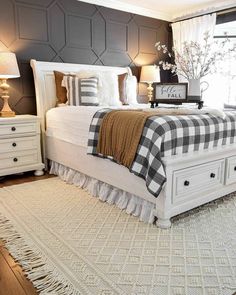 a white bed sitting in a bedroom on top of a wooden floor next to a window