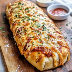 a cheesy pizza on a wooden cutting board with sauces and parsley