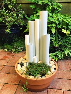 a potted plant with candles and rocks in it