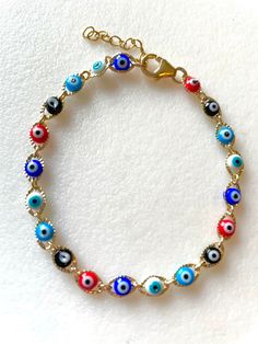 Dainty petite evil eye chain link bracelet with cobalt blue, aqua, red, white and black tiny enameled evil eyes. Delicate evil eye gold link bracelet closes with 14k gold fill lobster claw clasp and 1 inch extension. Handmade Metal Evil Eye Bracelet, Multicolor Evil Eye Jewelry, Multicolor Round Evil Eye Jewelry, Multicolor Evil Eye Round Bracelets, Multicolor Round Evil Eye Bracelets, Multicolor Adjustable Chain Bracelet, Blue Metal Bracelets With Evil Eye, Blue Metal Bracelet With Evil Eye, Multicolor Evil Eye Bracelets