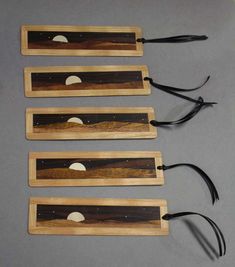 four pieces of wood with black handles and white circles on them, sitting next to each other