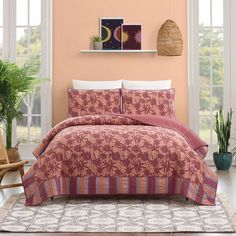 a bed in a room with pink walls and white trim on the headboard, along with potted plants