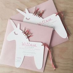 three pink envelopes with an unicorn on the front and one in the back, tied together