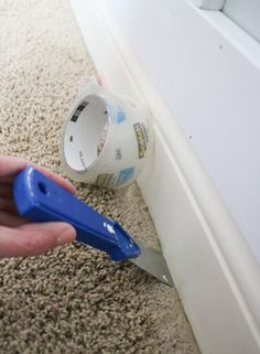 a person is using a pair of scissors to cut the carpet