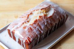 a loaf of glazed donut sitting on top of a white plate with icing