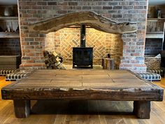 a large wooden table sitting in front of a brick fireplace