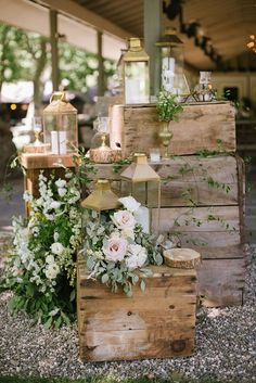 an instagram photo with flowers and candles on top of wooden crates in front of trees