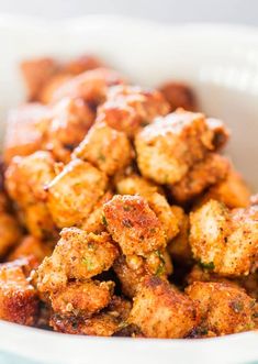 a white bowl filled with fried food on top of a table