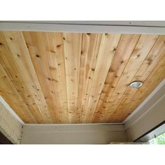 the ceiling is made of wood planks and has a light fixture on it's side