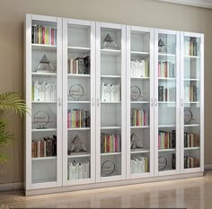 a white bookcase filled with lots of books on top of a hard wood floor