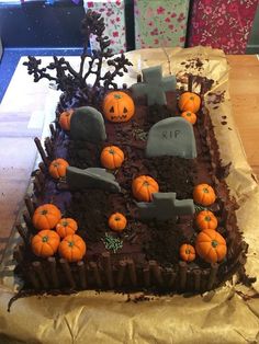 a cake decorated with pumpkins and tombstones