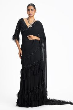 Black pre-draped saree with placement sequins, crystal embellishments, ruffle and feather detailing. Paired with a padded blouse with all over sequins, crystal embellishments.
Components: 2
Pattern: Embellished
Type Of Work: Sequins, Crystals, Beads
Neckline: V Neck
Sleeve Type: Three Quarter Sleeves
Fabric: Georgette
Color: Black
Other Details: 
Blouse:
Padded
Faux fur trimmed cuffs
Note: All the jewellery worn by the model is not for sale
Occasion: Sangeet - Aza Fashions Classy Saree, Velvet Applique, Skirt With Ruffles, Draped Saree, Organza Blouse, Crystals Beads, Padded Blouse, Drape Saree, Indian Blouse