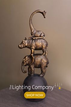 an elephant and cub statue on top of a ball with the caption lighting company shop now