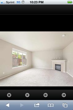 an empty room with a fireplace and windows