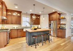 a large kitchen with wooden floors and lots of counter space, including an island in the middle