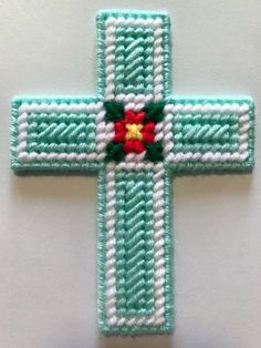 a cross made out of green and white yarn