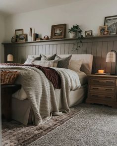 a bedroom with a bed, nightstands and pictures on the wall above it is shown