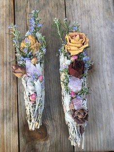 two vases with dried flowers are sitting on a wooden table