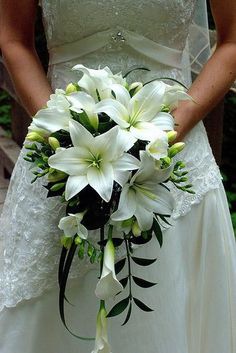 a bride holding a bouquet of white flowers