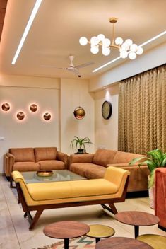 a living room with couches, tables and lamps on the ceiling is lit by recessed lights