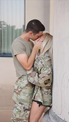 a man and woman kissing in front of a building