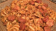 a close up of a plate of food with pasta and sausages on it's side