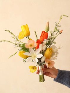 a person holding a bouquet of flowers in their hand