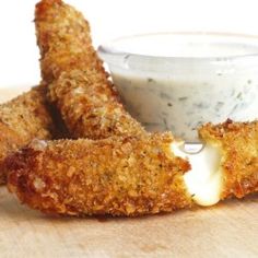 fried chicken sticks with ranch dressing on a cutting board