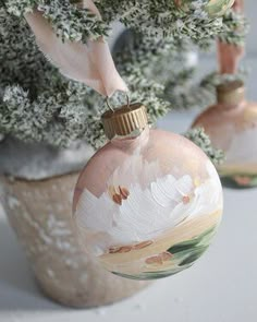 two glass ornaments hanging from a tree