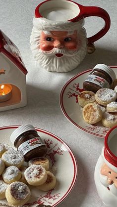 there are three plates with cookies on them and a santa clause mug next to it