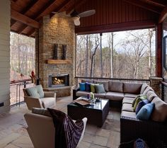 a covered patio with couches, chairs and a fire place in the middle of it