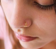 a close up of a woman's nose with a gold nose ring on it