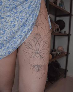 a woman's thigh with a flower tattoo on it